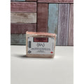 Cedarwood  bar of soap with a label on a white surface and wooden background