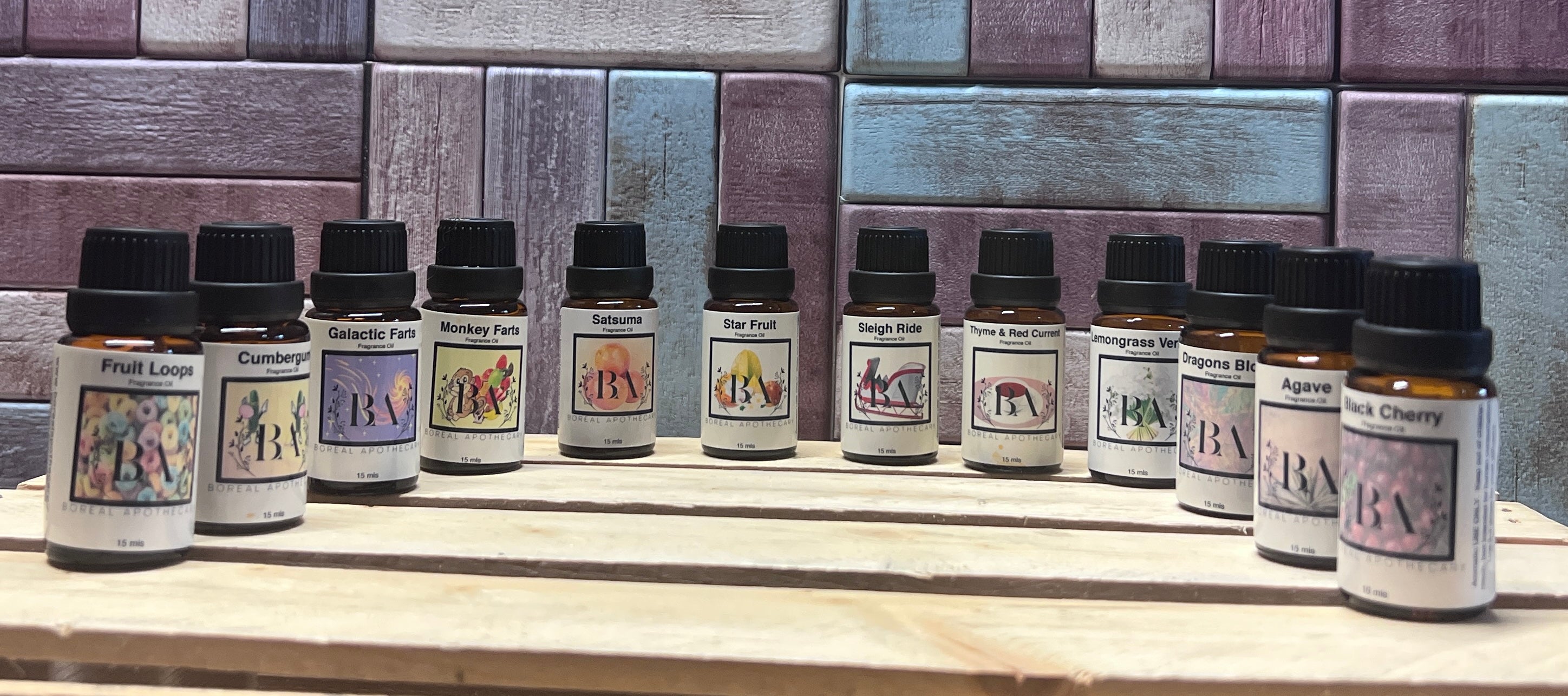 Row of small bottles with labels on a wooden surface against a tiled wall background