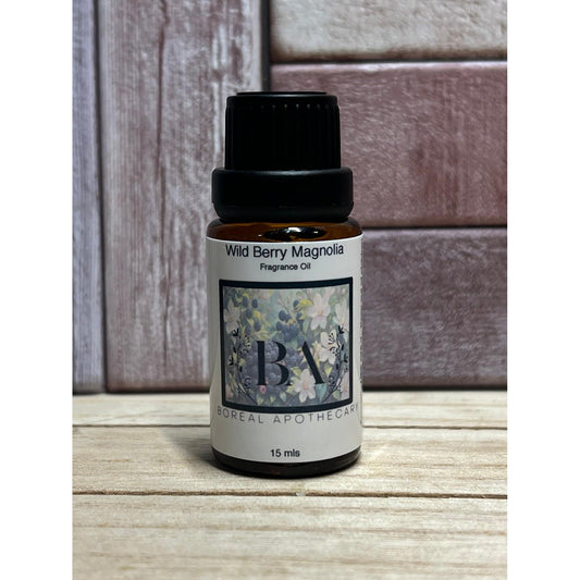 Bottle of Wild Berry Magnolia fragrance oil on a wooden surface with a wooden background