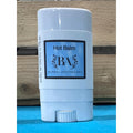 Boreal Apothecary Hot Balm stick on a blue surface with wooden background