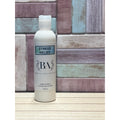 Bottle of 'Stress Relief' lotion by BA Lorient Apothecary on a wooden surface with a tiled wall background.