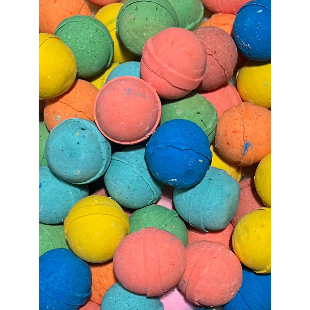 surprise bath bomb by boreal apothecary. Colourful bath bombs in various shades including green, blue, pink, and yellow. with a tiny toy hiding inside 