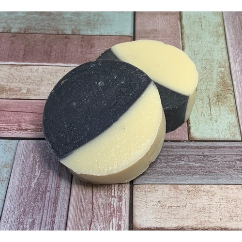 Two-tone black and beige,  Charcoal & Zinc Bar Soaps on a wooden surface