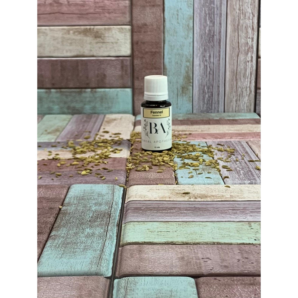Bottle of fennel essential oil on a wooden surface with scattered fennel seeds.