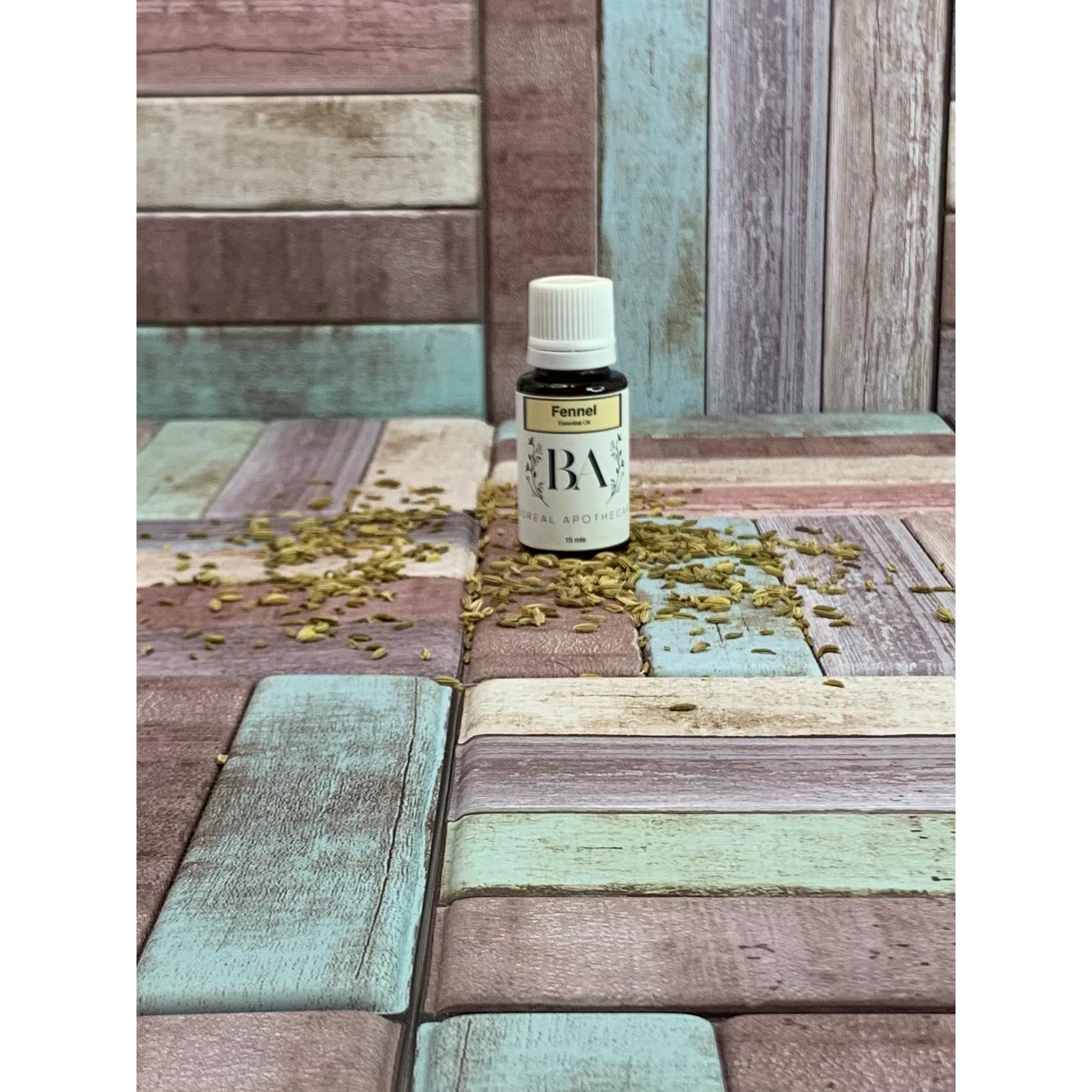 Bottle of fennel essential oil on a wooden surface with scattered fennel seeds.