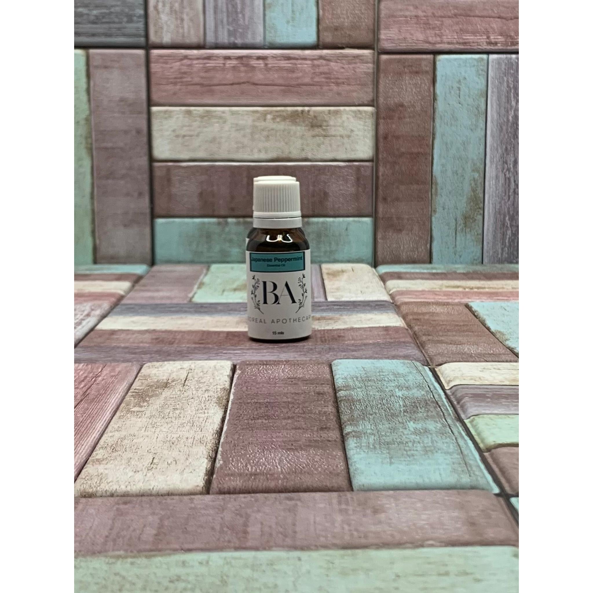 Small bottle labeled Japanese Peppermint Essential Oil on a mosaic tile background