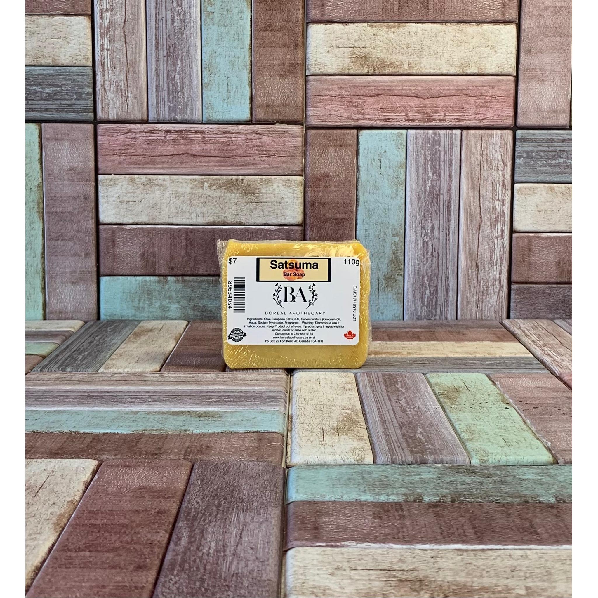 Bar of yellow Satsuma soap with a label on a wooden background