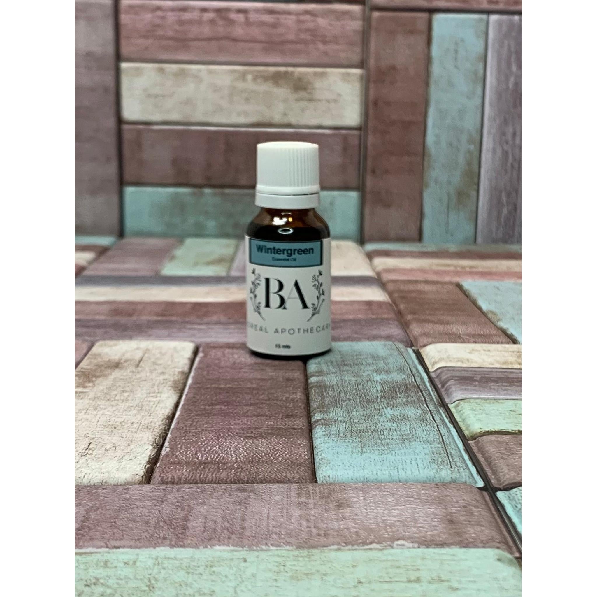 Bottle of Wintergreen essential oil on a multi-coloured tiled surface