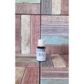 Bottle of  chill out essential oil blend on a wooden surface with a multi coloured background