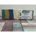 Two bars of soap, one wrapped and one with a label, on a wooden surface.