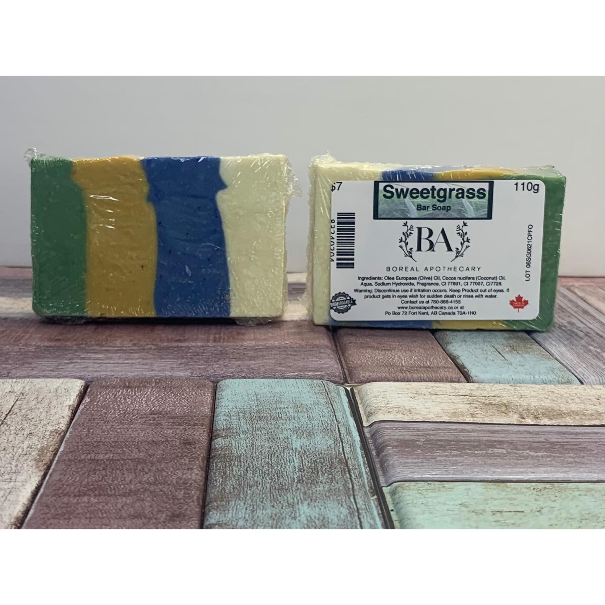 Two bars of soap, one wrapped and one with a label, on a wooden surface.